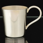 METAL PRATEADO, uma (1) caneca pequena, lisa, alça curvilínea, sem marca de manufatura aparente, medindo 5 cm altura e 4,5 cm diâmetro mais a alça, vide foto.