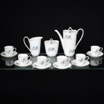 PORCELANA, conjunto para café com nove (9) itens: 1 bule, 1 cremeira, 1 açucareiro e 6 xícaras, ornamentação floral na tonalidade azul, arremates com frisos a ouro, marca STEATITA (Campo Largo, PR, funcionou de 1954 a 1994), medindo a maior peça 18,5 cm altura, sem uso e acondicionado na caixa, ideal para presente, vide foto.