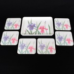 DIVERSOS, conjunto italiano com sete (7) itens: 1 bandeja retangular e 6 porta copos quadrangulares, confeccionados em polímero na tonalidade branca com ornamentação policromada representando orquídeas de jardim, marca MEBEL, Made in Italy marcada em uma das peças, medindo respectivamente 18,5 x 14 cm e 9,5 x 9,5 cm, vide foto.