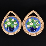 AZULEJO OU PORCELANA, par (2) descansos para panela, relevados em vaso de flor, policromados, fixados sobre suporte em tresse de fibra vegetal, medindo aproximadamente 21 cm diâmetro mais prolongamento para pendurar, vide foto.