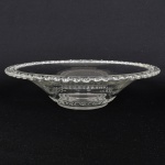 VIDRO, uma (1) fruteira ou centro de mesa, incolor e translúcida, modelada com barrado contínuo, intercalado com S e tracejado, medindo 31 cm diâmetro e 7,5 cm altura, vide foto.