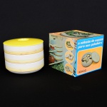 PORCELANA, três (3) travessas cilíndricas de borda alta, empilháveis, ornadas com frisos na tonalidade amarela, possui tampa em polímero, marca VERACRUZ (Pedreira, SP, 1966 a 2001, em 1966 a Cerâmica Santana adquiriu da Nadir Figueiredo as antigas instalações da Fabrica Santa Rita e fundou a Porcelana Veracruz, para produção de louças domésticas, a partir de 2001 foi incorporada pela própria Santana e passou a produzir apenas isoladores elétricos), medindo cada travessa 16,5 cm diâmetro e 5 cm altura, altura total empilhada 12 cm, acondicionadas na caixa original, ideal para presente, vide foto.