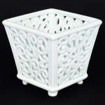 PORCELANA, um (1) vaso tipo cachepô, formato trapezoidal, vazado em volutas, base com quatro pés, sem marca de manufatura aparente, tonalidade verde claro, medindo 10 x 10 x 9,5 cm, vide foto.