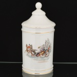 PORCELANA, um (1) pote cilíndrico para toucador, tampa quase cônica com terminação esférica, ornamentação policromada com cena do gênero representando charrete puxada por parelha de cavalos, marca SALER (Ernesto & Hugo Saler Ltda., Guarulhos, SP, ativo nas décadas 50/60), arremates com frisos a ouro já com sinais de desgastes, medindo 27,5 cm altura, vide foto.