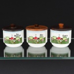 PORCELANA, três (3) porta condimentos cilíndricos, ornados com paisagem rural em policromia e as legendas: CANELA, NOZ MOSCADA e ALHO, tampa em madeira torneada, marca SCHMIDT (Pomerode, SC; Mauá, SP; Campo Largo, PR, fundada em 1945, ainda em atividade, maior fábrica de porcelana da América Latina), medindo 9 cm altura e 8 cm diâmetro, vide foto.