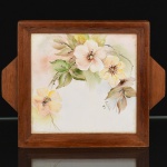 AZULEJO, uma (1) bandejinha quadrangular, pintada a mão em policromia, representando flores, assinada e datada CECÍLIA 89, moldura em madeira, medindo 17,5 x 17,5 cm mais as alças, vide foto.