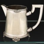 METAL PRATEADO, uma (1) antiga cremeira, ornada em frisos, padrão Art Nouveau, terminando em laçarotes, marca FRACALANZA (tradição desde 1884), medindo 14,5 cm altura até a alça, vide foto.