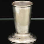 METAL PRATEADO, um (1) paliteiro obcônico liso, base em degraus, marca AEC (Abramo Eberle Companhia - Abramo Eberle 1880, Monte Magrè 1945, Caxias do Sul, veio com uma das primeiras levas de imigrantes italianos para o Brasil em 1884 junto com seus pais Giuzeppe Eberle e Luigia Zanrosso, seu pai abriu uma pequena funilaria mas como tinha que trabalhar na lavoura quem cuidava era a mãe e o pequeno Abramo ajudava na funilaria; em 1896 quando o pai resolveu vender a funilaria para concentrar os esforços da família na lavoura Abramo, com 16 anos de idade, se propôs a comprá-la do pai, em 1918 já com o nome Abramo Eberle & Cia iniciou a fabricação de talheres e utensílios de mesa, morreu em 1945 com 65 anos de idade e os filhos deram continuidade aos negócios até 1984 quando venderam para o Grupo Zivi), medindo 6,5 cm altura e 5,5 cm diâmetro, ligeiras mossas na base, vide foto.