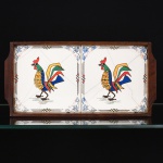 AZULEJOS, uma (1) bandeja retangular, ornamentação policromada representando galos, possuem diversas trincas, fixadas sobre eucatex, moldura em jacarandá, medindo 34 x 16,5 cm, vide foto.