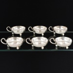 METAL PRATEADO, seis (6) taças para sobremesa, lisas, alças curvilíneas, pés esféricos, marca EBERLE (Abramo Eberle 1880, Monte Magrè 1945, Caxias do Sul, veio com uma das primeiras levas de imigrantes italianos para o Brasil em 1884 junto com seus pais Giuzeppe Eberle e Luigia Zanrosso, seu pai abriu uma pequena funilaria mas como tinha que trabalhar na lavoura quem cuidava era a mãe e o pequeno Abramo ajudava na funilaria; em 1896 quando o pai resolveu vender a funilaria para concentrar os esforços da família na lavoura Abramo, com 16 anos de idade, se propôs a comprá-la do pai, em 1918 já com o nome Abramo Eberle & Cia iniciou a fabricação de talheres e utensílios de mesa, morreu em 1945 com 65 anos de idade e os filhos deram continuidade aos negócios até 1984 quando venderam para o Grupo Zivi), medindo 8,5 cm diâmetro mais a alça, vide foto.
