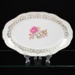 PORCELANA, uma (1) travessa oval, ornamentação central com rosas em policromia, barrado em flores e frisos a ouro, marca SCHMIDT (Pomerode, SC; Mauá, SP; Campo Largo, PR, fundada em 1945, ainda em atividade, maior fábrica de porcelana da América Latina), medindo 33 x 21 cm, vide foto.