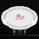 PORCELANA, uma (1) travessa oval, ornamentação central com rosas em policromia, barrado em flores e frisos a ouro, marca SCHMIDT (Pomerode, SC; Mauá, SP; Campo Largo, PR, fundada em 1945, ainda em atividade, maior fábrica de porcelana da América Latina), medindo 36,5 x 23,5 cm, vide foto.