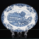 FAIANÇA INGLESA, uma (1) travessa oval, série ENGLISH COUNTRY LIFE, marca JOHNSON BROTHERS Ltd. (fabrica de faiança fundada em Hanley, Stoke-on-Trent, Inglaterra, no ano de 1883, empresa de quatro irmãos: Alfred, Frederick, Henry e Robert filhos de Robert Johnson, netos da linhagem Meakin, em 1968 se juntou ao grupo Wedgwood, em 2003 transferiu a fabrica para a China), ornada em paisagem com cena do gênero, charrete, cachorro e edificações, borda em pérgulas, volutas e elementos vegetalistas, tonalidades azul e branca, medindo 30 x 23,5 cm, vide foto.