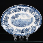 FAIANÇA INGLESA, uma (1) travessa oval, modelo AVON SCENES PALISSY, marca ROYAL WORCESTER Ltd. (fundada em 1751 como The Worcester Tonquin Manufactory, por John Wall; William Davis e mais treze empresários documentos originais da Sociedade, encontram-se preservados no Museu de Porcelana de Worcester; em 1783 foi vendida para Thomas Flight; em 1788 recebeu autorização real do Rei George III; em 1792 Martin Barr ingressou na Sociedade e virou Flight & Barr; em 1840 fundiu-se com a Chamberlain e virou Chamberlain & Company; em 1850 foi reconstruída após um incêndio, já com novos proprietários William Henry Kerr e Richard William Binns; em 1862 virou Royal Worcester Porcelain Company Ltd., após aposentadoria de Kerr e associação de Binns a Edward Philips; em 1889 assumiram o controle da Grainger & Co., seu nome foi usado até 1902; em 1905 adquiriu a James Hadley & Sons; em 1976 fundiu-se com a Spode), tonalidade azul sobre fundo branco, ornados em paisagem com cena do gênero, edificações e elementos vegetalistas, borda com barrado em flores e volutas, medindo 36 x 28 cm, vide foto.
