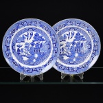 FAIANÇA INGLESA, par (2) pratos rasos, ornamentação WILLON (Segundo a lenda chinesa: Um certo Mandarim tinha uma leal e devotada filha, possuidora de rara beleza. Certo dia, em que descobre que ela estava apaixonada por um carteiro que lhe fazia a corte, e que era por ela correspondida, expulsa a filha de casa e roga-lhe uma praga: que ao ser trocado o primeiro beijo pelo casal, eles se transformariam em dois pombos), dita POMBINHOS, tonalidade azul e branca, marca RIDGWAY (Ralph Ridgway 1726 a ? primeiro oleiro da família teve 3 filhos mas somente dois seguiram a mesma profissão do pai, são eles: George Ridgway 1757 a 1823 e Job Ridgway 1759 a 1814 que trabalharam juntos na Bell Works entre 1782 e 1802, quando se separaram George permaneceu na empresa e Job abriu a Cauldon Place 1802 a 1808, em 1806 os irmãos trabalharam novamente em parceria na Bellevue Pottery, em 1808 Job uniu a Bell Works e Cauldon Place e a razão social passou a ser Job Ridgway & Sons 1808 a 1814, em 1814 com a morte de Job a empresa ficou para seus 2 filhos John Ridgway 1785 a 1860 e William Ridgway 1788 a 1864, a razão social mudou para John & William Ridgway 1814 a 1830, em 1830 os irmãos se separaram William ficou com a Bell Works {por conta própria, mas também com seu filho Edward John Ridgway 1814 a 1896 e outros parceiros chegou a controlar 6 olarias, aposentou-se em 1854, seu filho continuou parte dos negócios, em 1866 mudou-se para Shelton, em 1870 colocou os filhos na sociedade, em 1872 aposentou-se, seus filhos John & Edward Ackroyd Rigdway continuaram os negócios, posteriormente juntaram-se a Joseph Sparks, em 1955 virou subsidiária da Allied English Potteries, atualmente é subsidiária da Royal Dolton Tablewares Ltd} e John ficou com a Cauldon Place, {John Ridgway & Co 1830 a 1855; John Ridgway, Bates & Co 1856 a 1858; Bates, Brown-Westhead & Co 1858 a 1862; Brown-Westhead Moore & Co 1862 a 1962, fechou), tonalidade azul e branca, medindo 24 cm diâmetro, vide foto.
