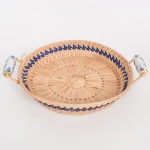 DIVERSOS, uma (1) cesta circular, confeccionada em tresse de fibra vegetal, alças em louça com pintura vegetalista na técnica blue and white, medindo 31 cm diâmetro mais as alças, vide foto.