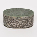 DIVERSOS, uma (1) caixa porta joias oval, confeccionada em metal prateado, ornamentação relevada em elementos vegetalistas estilizados, parte interna com forração em tecido aveludado vermelho e desbotado, sem marca de manufatura aparente, medindo 8,5 x 5,5 x 3,5 cm, vide foto.