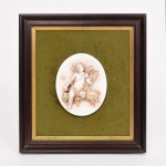 PORCELANA, uma (1) antiga placa oval relevada em anjo, borboleta e fecho de trigo, uma das pernas do anjo quebrada e faltando, numerada na borda 250/50, e marca não identificada representada pela letra E em azul, fixada sobre moldura em madeira com fundo em feltro na tonalidade verde, medindo a placa 14 x 11 cm, moldura 31,5 x 28,5 cm, vide foto.