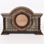 RELÓGIO, um (1) antigo de mesa, cornija ou estante, marca IMHOF (Manufacture de Pendulette D Art Arthur Imhof S/A, localizada em La Chaux-de-Fonds, Suíça; fundada em 1888 por Frederick Imhof, inicialmente fabricava mostradores para relógios de outras fábricas, pouco tempo depois já produzia relógios completos de mesa, pêndulo e mais tarde pulso; seu modelo de maior sucesso foi o Tower of Berne; em 1960 lançou um relógio no formato de gaiola com mecanismo autômato representando pássaro dotado de penas coloridas que canta e bate as asas; na mesma década de 60 lançou o relógio de mesa Tempus Fugit com corda para 8 dias; a empresa recebeu o apelido de Rolls-Royce dos relógios), mecanismo a corda para 8 dias, parado e não testado, gabinete em madeira com detalhes em goivados e tremidos, placagem em jacarandá, apliques em prata relevada em flores, perolados e conchas, medindo 40,5 x 27 x 8 cm, vide foto.