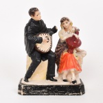 ESCULTURA, um (1) grupo escultórico figurativo representando casal de portugueses em trajes típicos, confeccionada em cerâmica ou estuque, policromada, faltam pequenas partes, medindo 25 cm altura, vide foto.