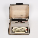 DIVERSOS, uma (1) máquina de datilografia, marca OLIVETTI, modelo LETTERA 35, portátil, tonalidade cinza, acondicionada em estojo do tipo maleta, vide foto.