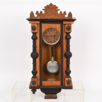 RELÓGIO, um (1) antigo de parede, mecânico, sem marca de manufatura aparente, mostrador com algarismos arábicos e dois furos (sinaliza a cada meia hora e hora cheia), gabinete em madeira, portinhola e ilhargas envidraçadas, apliques variados em falsas colunetas, escudos, etc., acompanham pêndulo e chave borboleta, não testado, medindo 70 cm altura, vide foto.