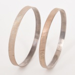 JOIAS, par (2) pulseiras lisas, com frisos diagonais, confeccionadas em PRATA, contrastadas 925 milésimos, medindo 6,5 cm diâmetro, peso total aproximado 23 gr., vide foto.