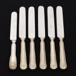 METAL PRATEADO, seis (6) facas de sobremesa com lâminas em aço, ornadas com frisos, duas manufaturas distintas, sendo: 1 da tradicional manufatura francesa CHRISTOFLE (fundada em Paris em 1830 por Charles Christofle); 5 da marca WOLFF (tradição desde 1894), todas medindo 19 cm comprimento, vide foto.