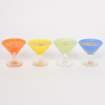DIVERSOS, quatro (4) velas aromáticas com castiçais em vidro, tipo taças de bojo obcônico, fuste cilíndrico e base em bolacha, incolores e translúcidas, bojo com esmaltação em tonalidades variadas, não aparentam uso, medindo 6,5 cm altura e diâmetro, vide foto.