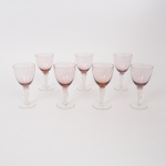 MURANO, sete (7) tacas de pé alto para vinho tinto, confeccionadas em vidro soprado na técnica dos Grandes Mestres Vidreiros de Murano, bojo com leve toque rosa, fuste em torçaide e base em bolacha, medindo 13,5 cm altura, vide foto.