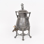PEWTER, um (1) antigo samovar, marca REED & BARTON (fundada no ano de 1824 por Isaac Babbitt, como Babbitt & Crossman, em Taunton, Massachusetts; pouco tempo depois foi vendida para Henry Gooding Reed e Charles E. Barton, tornando-se Reed & Barton; em 1928 fundiu-se com a Dominick & Half; em 2015 foi adquirida em um leilão de falência pela The Lenox Company), ornamentação em alto e baixo relevo representando elementos vegetalistas, pés com terminações em garras, falta o queimador, possui defeitos, medindo 44 cm altura, vide foto.