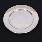AÇO INOX, uma (1) travessa circular, lisa, confeccionada na técnica de estamparia mecanizada, marca EBERLE (Abramo Eberle 1880, Monte Magrè 1945, Caxias do Sul, veio com uma das primeiras levas de imigrantes italianos para o Brasil em 1884 junto com seus pais Giuzeppe Eberle e Luigia Zanrosso, seu pai abriu uma pequena funilaria mas como tinha que trabalhar na lavoura quem cuidava era a mãe e o pequeno Abramo ajudava na funilaria; em 1896 quando o pai resolveu vender a funilaria para concentrar os esforços da família na lavoura Abramo, com 16 anos de idade, se propôs a comprá-la do pai, em 1918 já com o nome Abramo Eberle & Cia iniciou a fabricação de talheres e utensílios de mesa, morreu em 1945 com 65 anos de idade e os filhos deram continuidade aos negócios até 1984 quando venderam para o Grupo Zivi), medindo 30,5 cm diâmetro, vide foto.