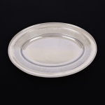 AÇO INOX, uma (1) travessa oval ornada com barrado vegetalista, marca PRATINOX, medindo 36,5 x 25,5 cm, vide foto.