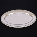 AÇO INOX, uma (1) travessa oval, borda canelada, confeccionada na técnica de estamparia mecanizada, marca MERIDIONAL, medindo 45 x 29 cm, vide foto.
