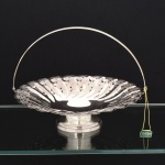METAL PRATEADO, uma (1) fruteira de pe baixo e com alça, bojo vazado em flores, borda recortada, marca AUREA  PRATA 90, ainda com etiqueta e sem uso, medindo 24 cm diâmetro, vide foto.