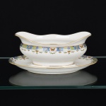 PORCELANA FRANCESA, uma (1) molheira com presentoir acoplado, borda ornada com barrado em policromia representando borboletas e flores, marca LIMOGES - U. C. (Union Ceramic)  FRANCE, arremates a ouro, medindo 23,5 cm comprimento, vide foto.