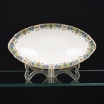 PORCELANA FRANCESA, uma (1) petisqueira oval, borda ornada com barrado em policromia representando borboletas e flores, marca LIMOGES - U. C. (Union Ceramic)  FRANCE, ANDRIEUX & Co., arremates a ouro, medindo 24 x 12,5 cm, vide foto.