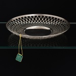 METAL PRATEADO, uma (1) fruteira baixa circular com gradil vazado, marca AUREA  PRATA 90, sem uso e com a etiqueta, medindo 25 cm diâmetro e 3,5 cm altura, vide foto.
