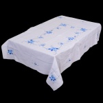 CAMA E MESA, uma (1) toalha retangular, confeccionada em tecido de linho na tonalidade branca, apliques em tecido colorido, bordado vegetalista em linha azul, medindo aproximadamente 180 x 124 cm, vide foto.