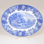 FAIANÇA INGLESA, uma (1) travessa oval com ornamentação dita FAZENDINHA, representando paisagem rural, borda com barrado floral, tonalidade azul sobre fundo branco, marca WOOD & SONS (fundada em 1865, funcionou na Potteries New Wharf em Trent e mais tarde na Pottery Stanley em Burlem, fechou em 2005), medindo 41,5 x 32,5 cm, vide foto.