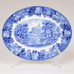 FAIANÇA INGLESA, uma (1) travessa oval com ornamentação dita FAZENDINHA, representando paisagem rural, borda com barrado floral, tonalidade azul sobre fundo branco, marca WOOD & SONS (fundada em 1865, funcionou na Potteries New Wharf em Trent e mais tarde na Pottery Stanley em Burlem, fechou em 2005), medindo 25,5 x 20 cm, vide foto