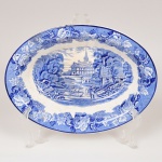 FAIANÇA INGLESA, uma (1) travessa oval de borda alta com ornamentação dita FAZENDINHA, representando paisagem rural, borda com barrado floral, tonalidade azul sobre fundo branco, marca WOOD & SONS (fundada em 1865, funcionou na Potteries New Wharf em Trent e mais tarde na Pottery Stanley em Burlem, fechou em 2005), medindo 25 x 18,5 x 5 cm, manchas, bicados na borda vistos principalmente pela parte de traz, vide foto.