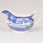 FAIANÇA INGLESA, uma (1) molheira com ornamentação dita FAZENDINHA, representando paisagem rural, borda com barrado floral, tonalidade azul sobre fundo branco, marca WOOD & SONS (fundada em 1865, funcionou na Potteries New Wharf em Trent e mais tarde na Pottery Stanley em Burlem, fechou em 2005), medindo 17 cm comprimento, vide foto.