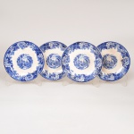 FAIANÇA INGLESA, quatro (4) pires de café descasados sem as xícaras, ornamentação dita FAZENDINHA, representando paisagem rural, borda com barrado floral, tonalidade azul sobre fundo branco, marca WOOD & SONS (fundada em 1865, funcionou na Potteries New Wharf em Trent e mais tarde na Pottery Stanley em Burlem, fechou em 2005), um deles com bicado acentuado, medindo 12 cm diâmetro, vide foto.