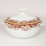 PORCELANA, uma (1) sopeira com tampa, ornada com faixa marrom e barrado vegetalista, arremates com frisos a ouro, modelo MON CHERI, marca RENNER (Porto Alegre, RS, fundada em 1942; em 1998 foi vendida para a Vista Alegre de Portugal; em 1999 mudou a razão social para Vista Alegre do Brasil), medindo 22,5 cm diâmetro mais as alças e 17 cm altura, vide foto.