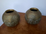 Par de potiches bojudos em latão amarelo com gravações de laços e flores. Apresenta pequenos amassados.14 cm alt