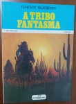 HQ Rara: Tenente Blueberry  A Tribo Fantasma (Charlier / Giraud)  Ed. Meribérica/Liber"A Tribo Fantasma" (La Tribu Fantôme) é um dos capítulos mais marcantes e maduros da saga do Tenente Blueberry. Com o traço genial e hiperdetalhado de Jean Giraud (que revolucionou os quadrinhos sob o pseudônimo de Moebius), a história mergulha profundamente no realismo cru do Velho Oeste americano, abordando as tensões entre o exército e as tribos nativas americanas. As edições de Blueberry da Meribérica são consideradas verdadeiros itens de luxo vintage devido à excelente fidelidade das cores e tradução cuidadosa, estando fora de catálogo há décadas.