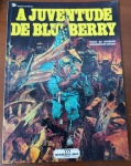 HQ Rara: A Juventude de Blueberry   (Charlier / Giraud)  Ed. Meribérica/LiberEste álbum histórico marca o início da série derivada (spin-off) que narra as peripécias e os traumas do jovem Mike Steve Donovan antes de se tornar o cínico e destemido Tenente Blueberry. Ambientado durante a sangrenta Guerra de Secessão Americana, o roteiro de Charlier mostra Blueberry agindo como infiltrado e espião, destrinchando as origens de sua personalidade. A arte explosiva de Jean Giraud retrata as batalhas civis americanas com um realismo visceral impactante. Impressa pela saudosa Meribérica/Liber, esta edição está fora de catálogo há décadas e é considerada item de luxo para os aficionados pela nona arte