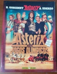 Livro Rara: Asterix nos Jogos Olímpicos  O Álbum do Filme (2008)  Editora RecordDiferente dos tradicionais álbuns ilustrados em traço de quadrinho, esta edição especial é a adaptação oficial em "foto-álbum" (fotofilme) do milionário filme em live-action de 2008. A narrativa acompanha os irredutíveis gauleses Asterix (Clovis Cornillac) e Obelix (Gérard Depardieu) ajudando o jovem Poetix a competir na Grécia Antiga para conquistar o coração da Princesa Irina. O livro traz ainda um encarte especial com "Os Segredos da Filmagem", revelando os bastidores dos efeitos visuais e da produção. Uma peça indispensável e muito nostálgica para colecionadores e fãs da maior franquia de banda desenhada da Europa.