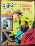 Tex Nº 150: O Sindicato do Ópio (1982)  Edição de Férias Vecchi  194 PáginasEste volume comemorativo de número 150 foi lançado com o selo especial "Edição de Férias", trazendo um bloco estendido de 194 páginas que resgata as primeiras e mais nostálgicas aventuras da juventude de Tex Willer. Por ser uma edição comemorativa marcante da reta final da Editora Vecchi (que faliu no ano seguinte), rodada em papel jornal clássico há mais de 40 anos, tornou-se um item de alta procura e essencial para colecionadores que desejam completar a cronologia histórica do ranger no Brasil.